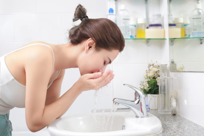 woman washing face bathroom home